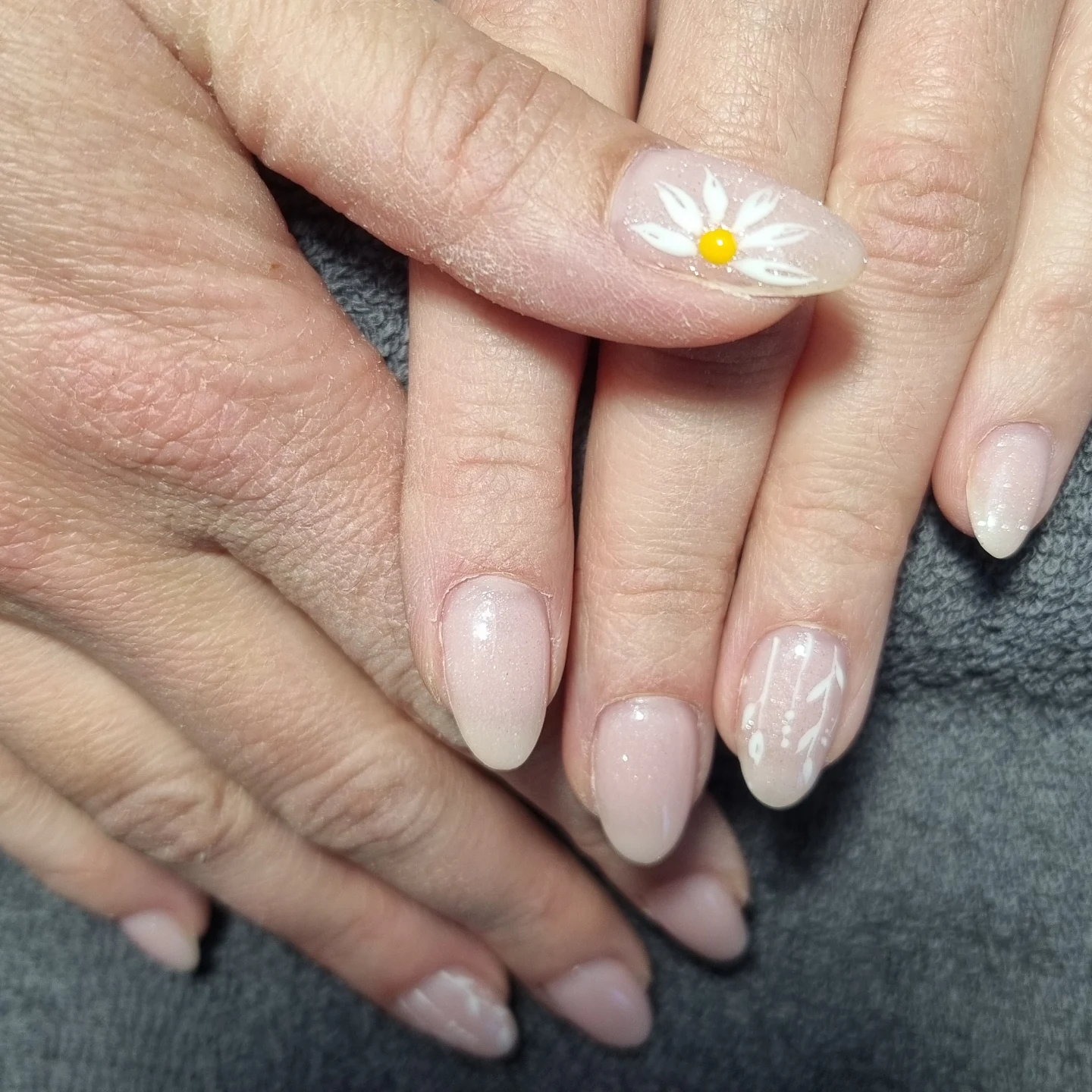 Manucure nude avec détails nail art floral marguerite