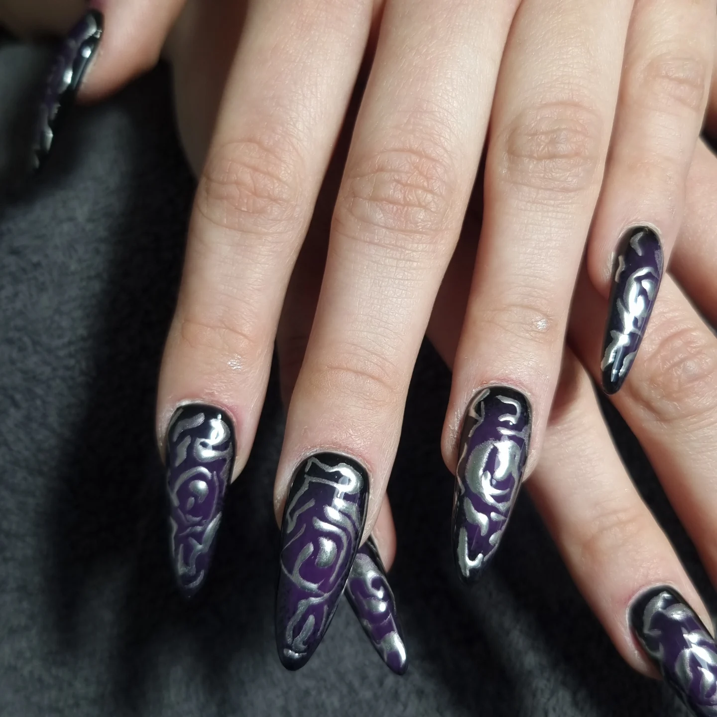 Ongles violets et noirs aux motifs gothiques argentés